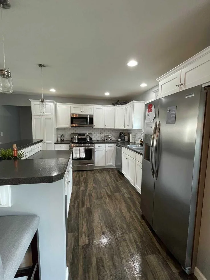 Bright, spotless kitchen with white cabinetry and stainless steel appliances